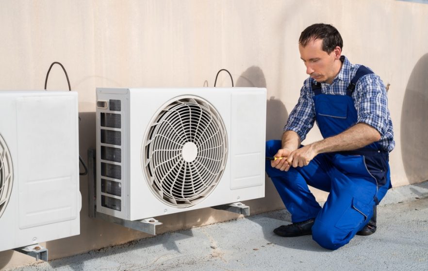 Male Technician Repairing Air Conditioner — Heating & Cooling in Central West NSW