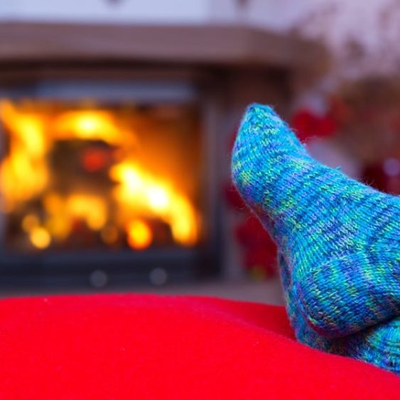 Person Wearing Warm Socks Relaxing by the Fire — Heating & Cooling in Central West NSW