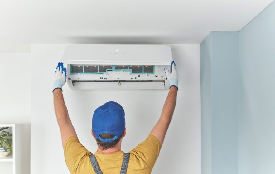 Repairman Cleaning and Fixing an AC unit — Heating & Cooling in Blayney NSW